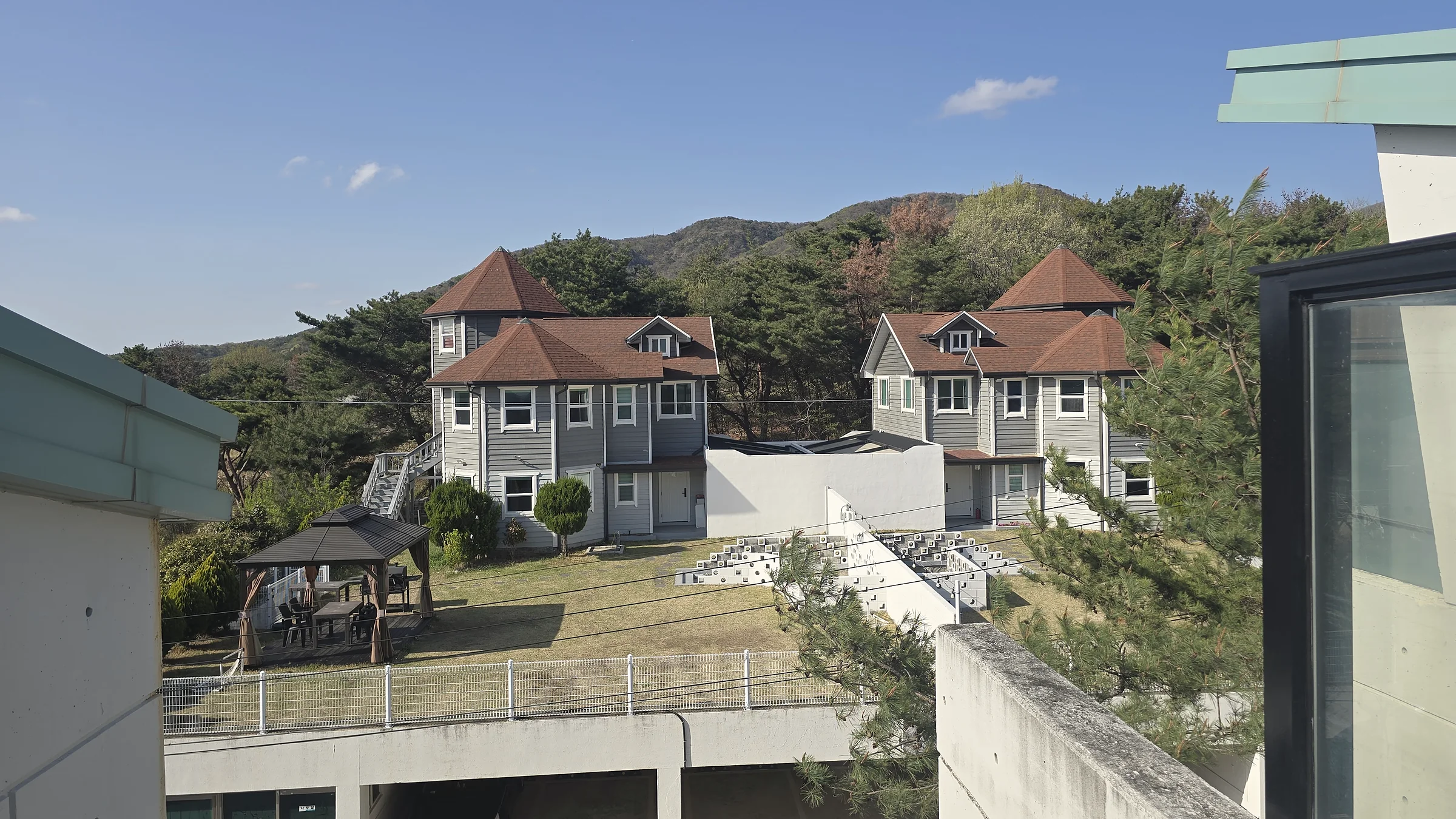 창밖으로 내려다본 잔디마당과 두 채의 독채, 뒤로 산