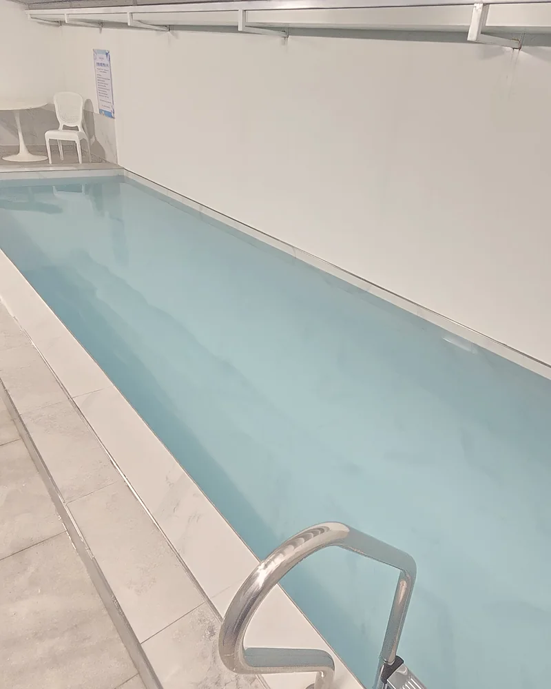 손잡이가 달린 계단으로 내려가는 수영장 입구